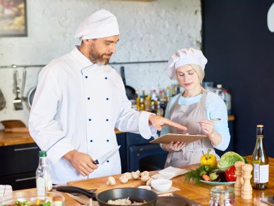 Immagine che mostra una giovane ragazza mentre aiuta uno chef. È usata come immagine del corso gratuito "AIUTO CUOCO" del progetto GOL